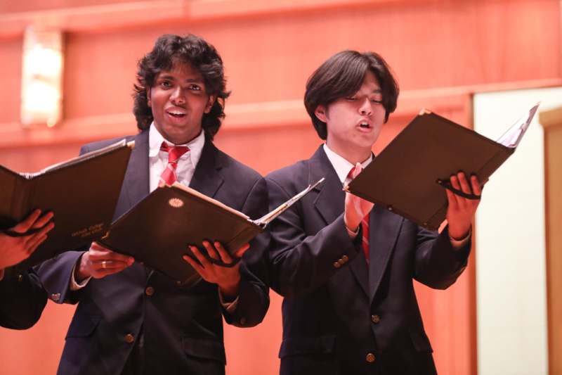 a group of men in suits holding books