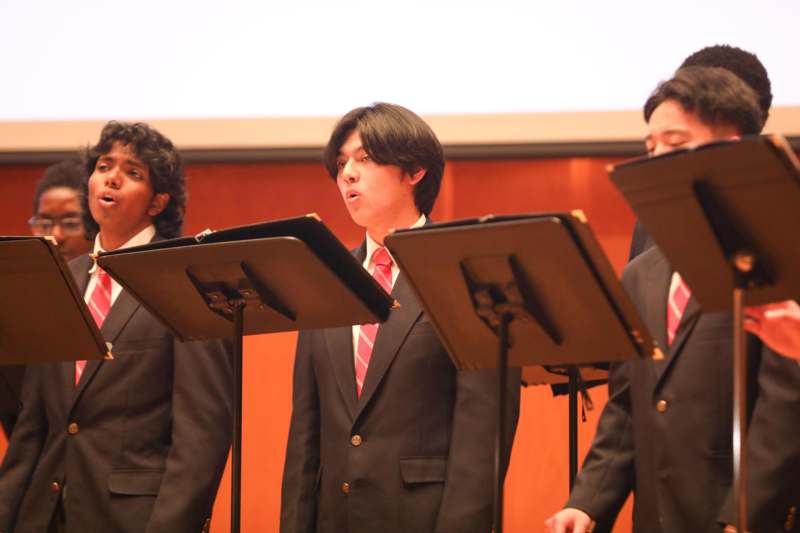 a group of men in suits standing in front of a stage