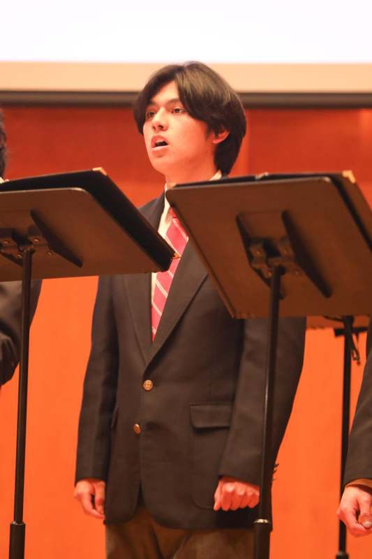 a man in a suit and tie standing in front of a microphone