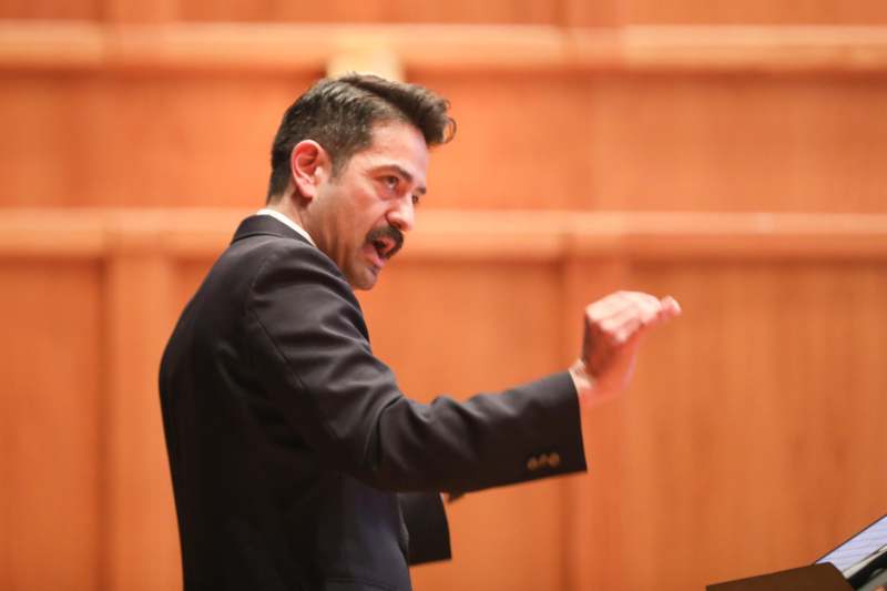 a man with a mustache speaking into a microphone