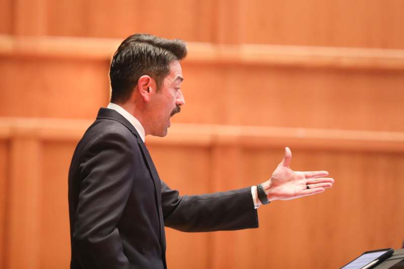 a man in a suit with his hand out