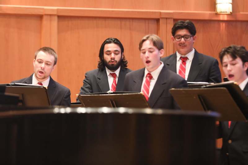 a group of men singing in front of a podium