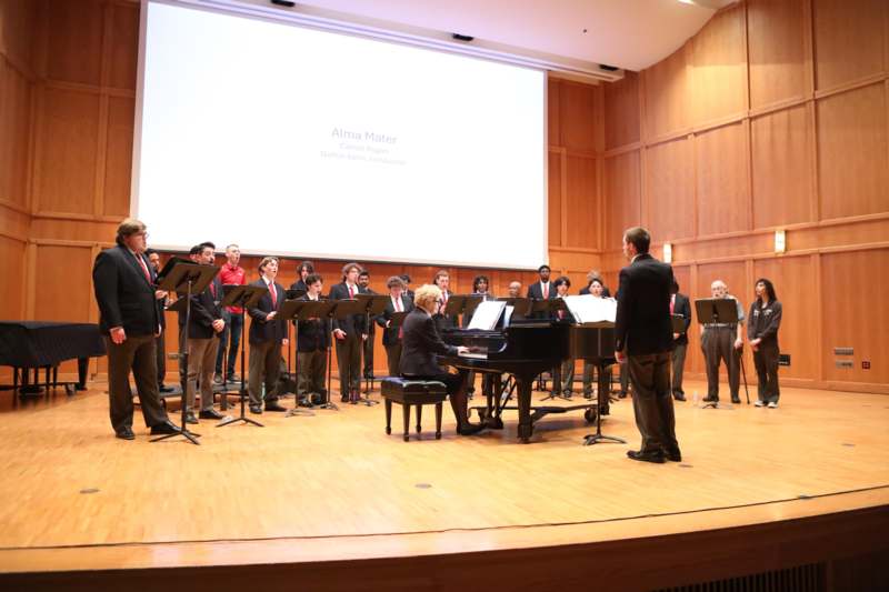 a group of people performing in front of a screen