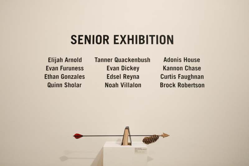 2026 Senior Art Opening Reception - an arrow on a white stand