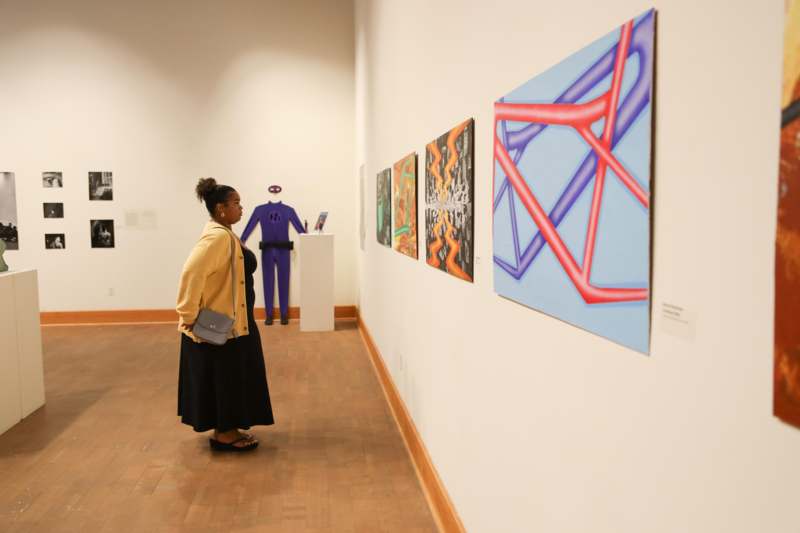 a woman looking at art on a wall