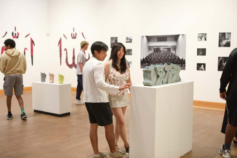 a man and woman looking at a sculpture