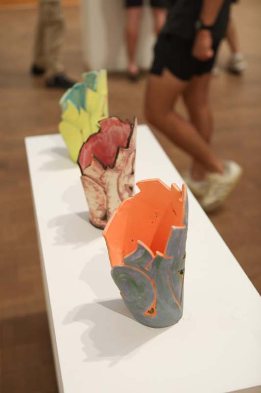 a group of colorful vases on a white table