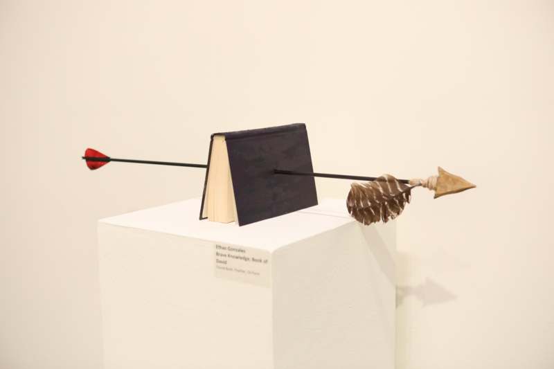 a book and arrow on a white pedestal