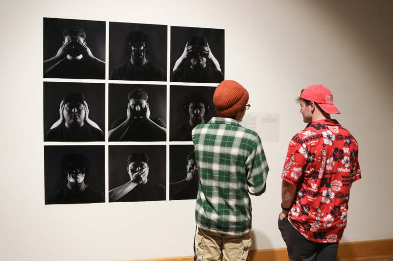 a group of people looking at pictures on a wall
