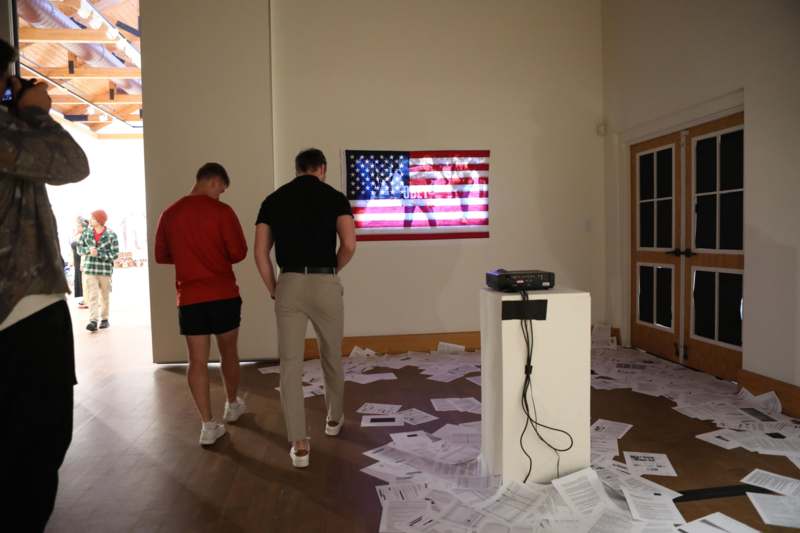 a group of men standing in a room with a flag on the wall