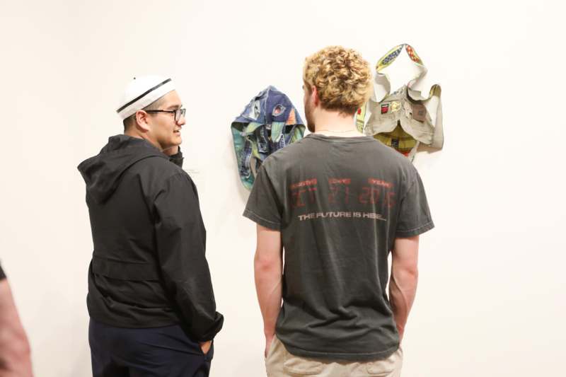 two men looking at clothes on a wall