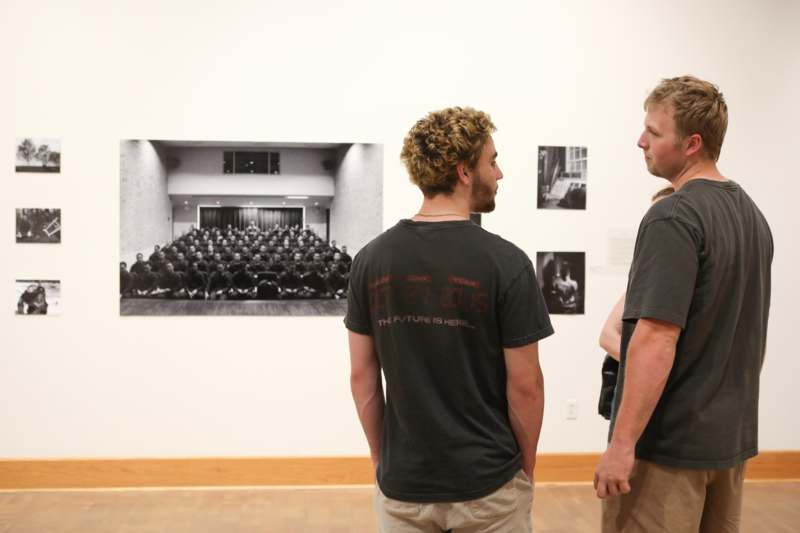 two men looking at a picture on a wall