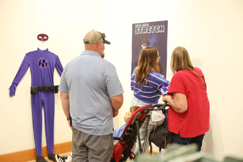 a group of people looking at a child in a stroller