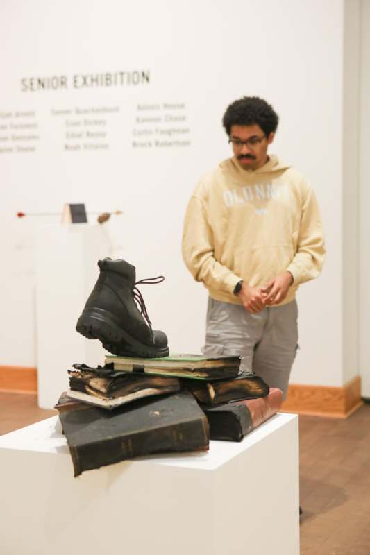 a man standing next to a pile of books