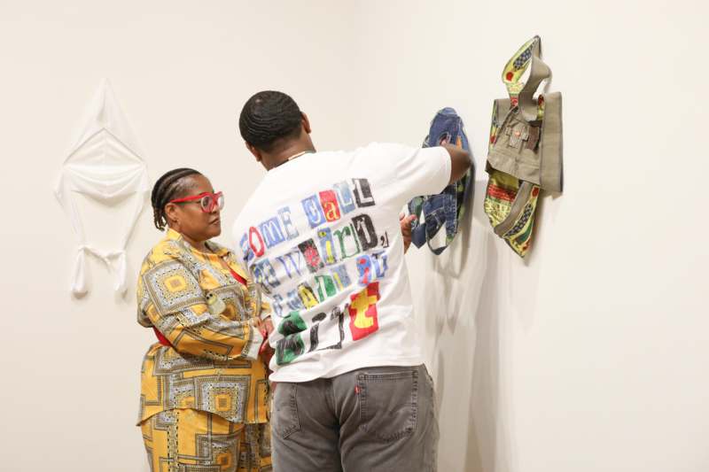 a man and woman looking at bags on a wall