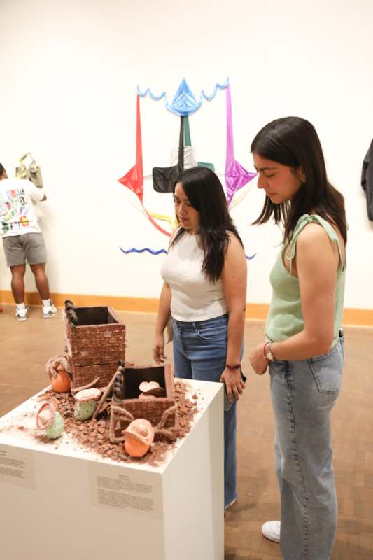 a group of women looking at a sculpture
