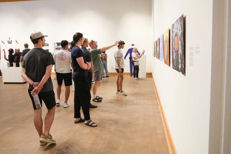 a group of people looking at art on a wall