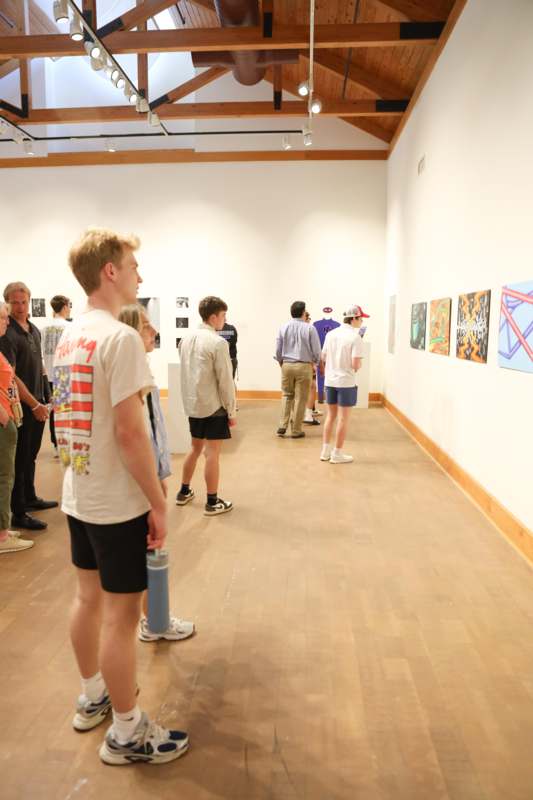 a group of people in a room with art on the wall