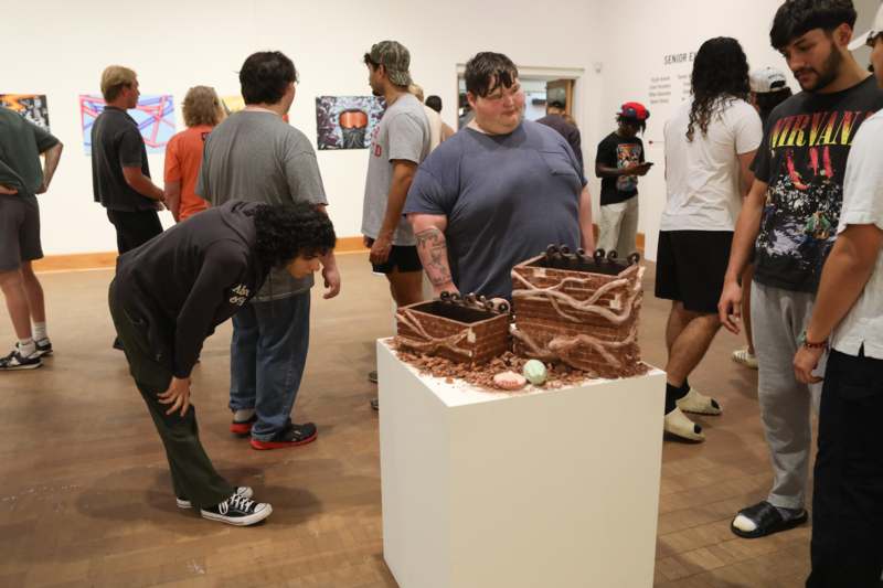 a group of people standing around a sculpture