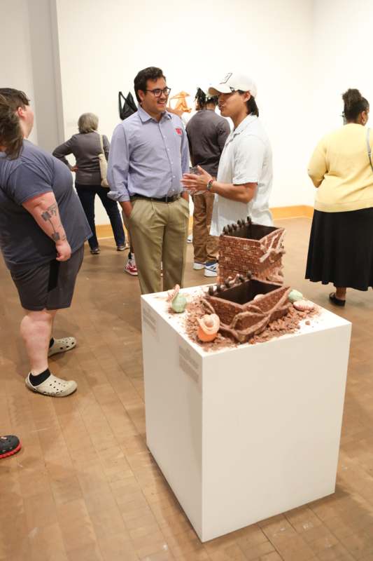 a group of people standing around a sculpture