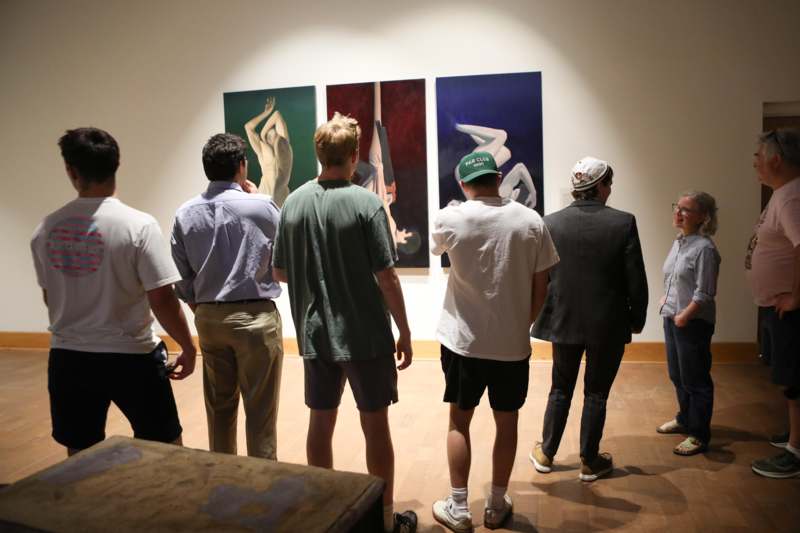 a group of people looking at paintings