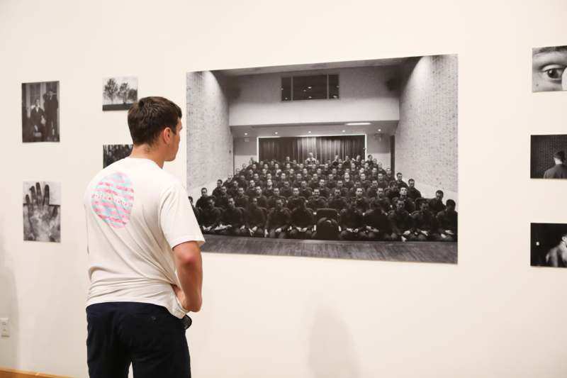 a man looking at a picture on a wall