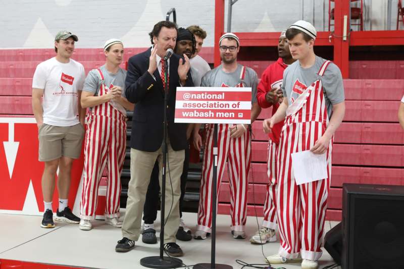 a group of men wearing striped overalls and a microphone