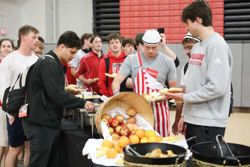 a group of people standing around a table full of food