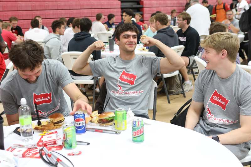 a group of men sitting at a table with food and drinks