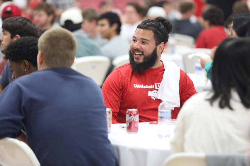 a man sitting at a table with a white towel around his neck
