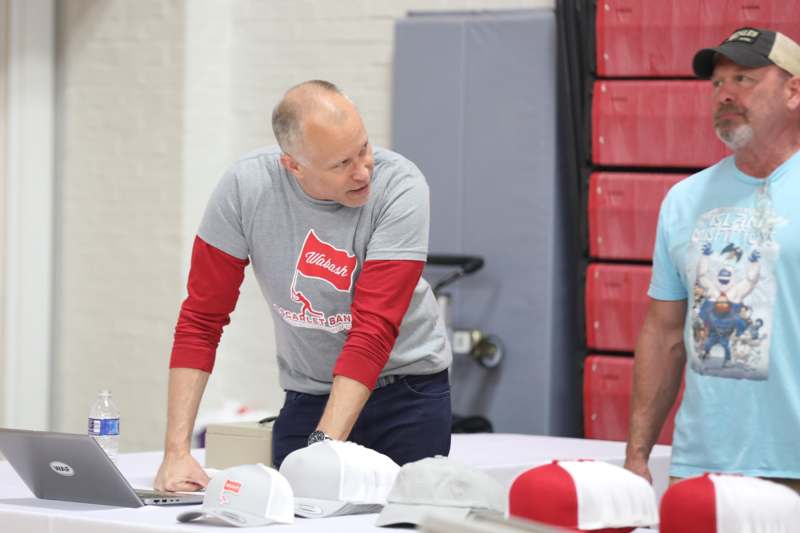 a man standing next to a table with hats