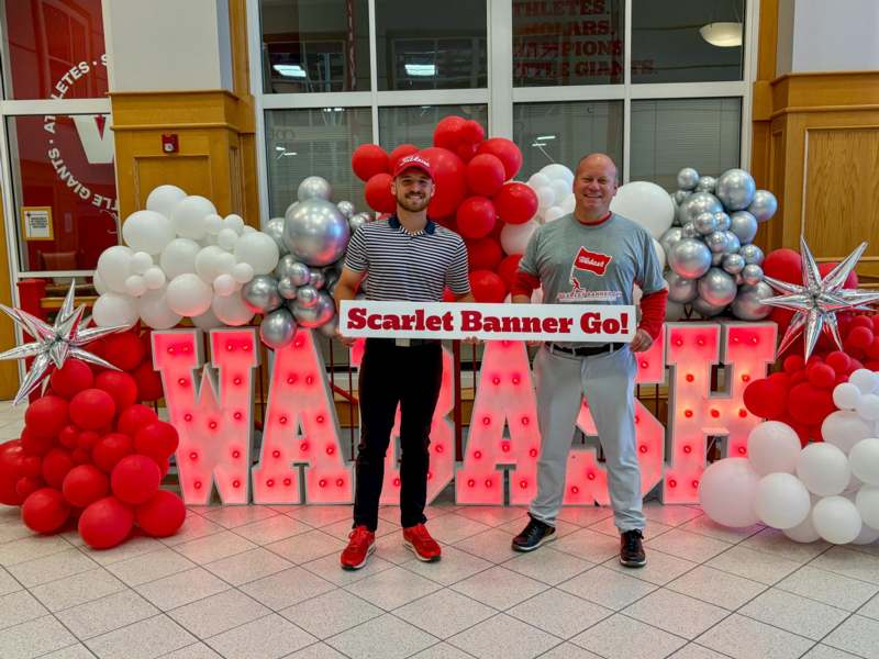 two men standing in front of balloons