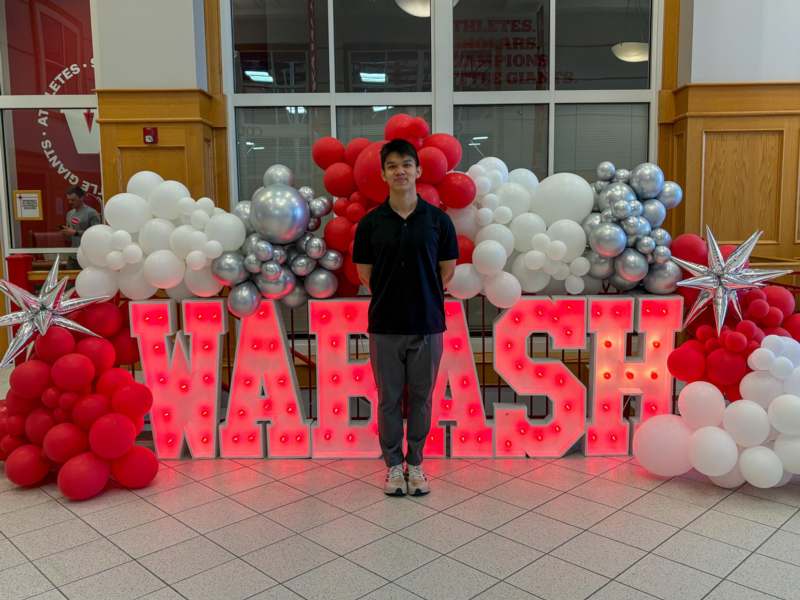 a man standing in front of a large red and white balloon display