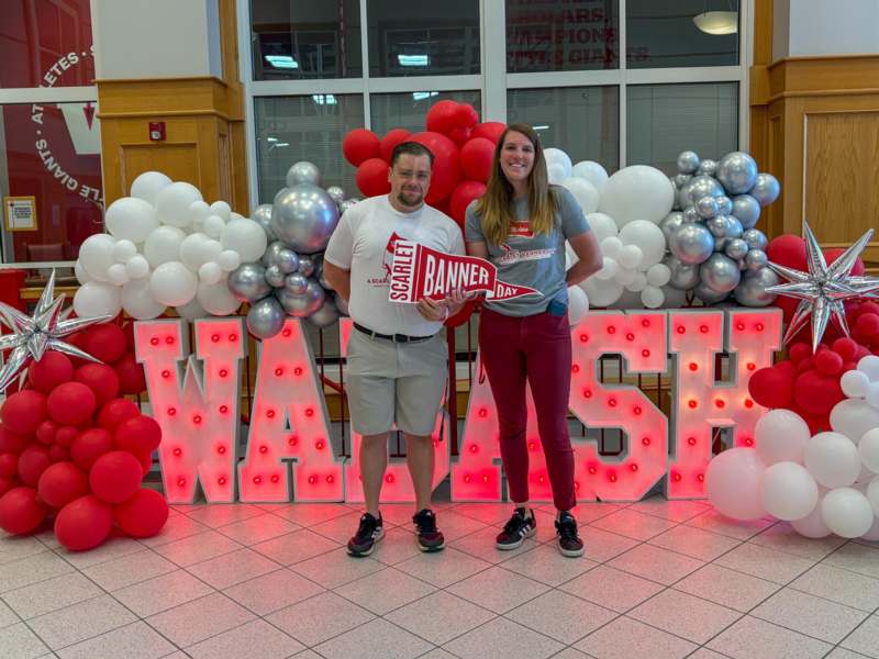 a man and woman standing in front of balloons