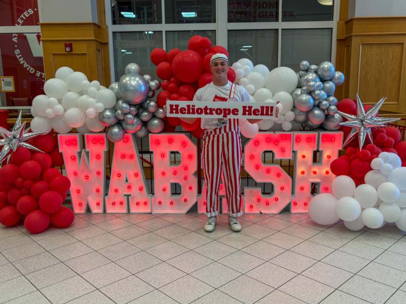 a man holding a sign in front of balloons