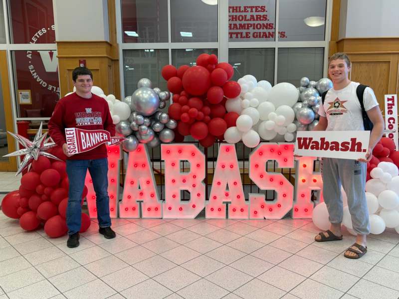 a group of people standing in front of a large sign