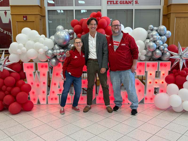 a group of people standing in front of balloons