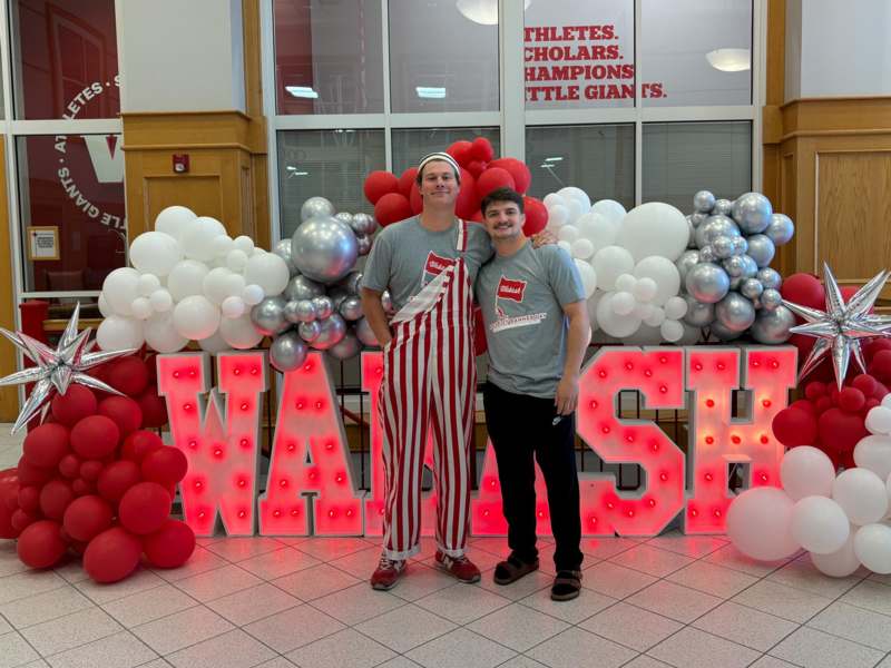 two men standing in front of balloons