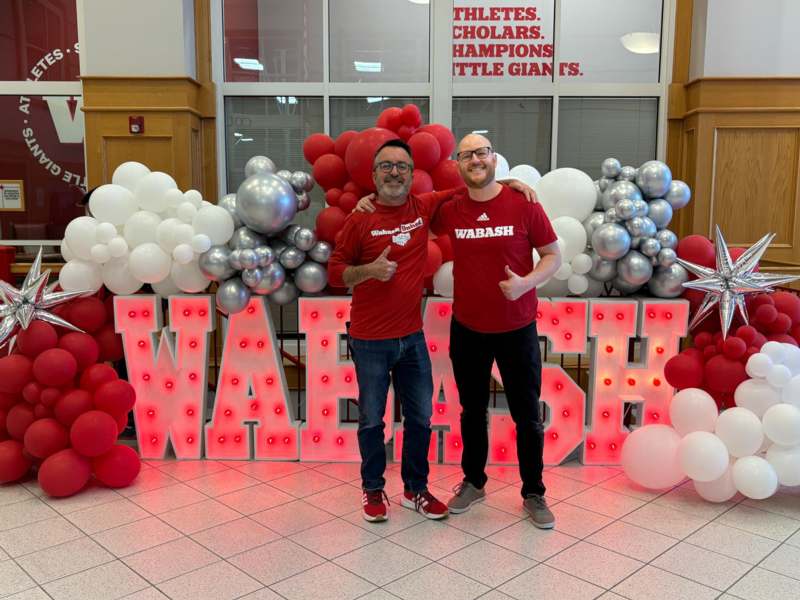 two men standing in front of balloons