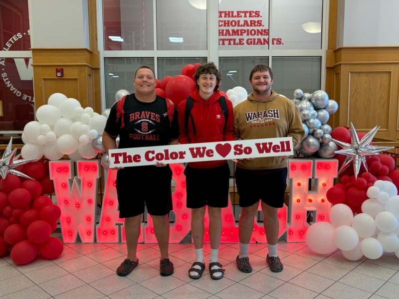 a group of men standing in front of balloons
