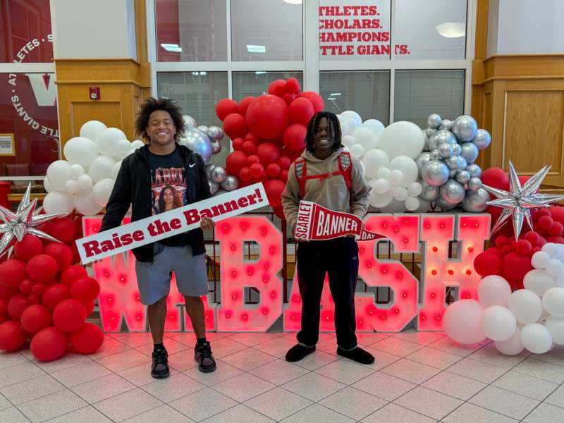 two men standing in front of balloons