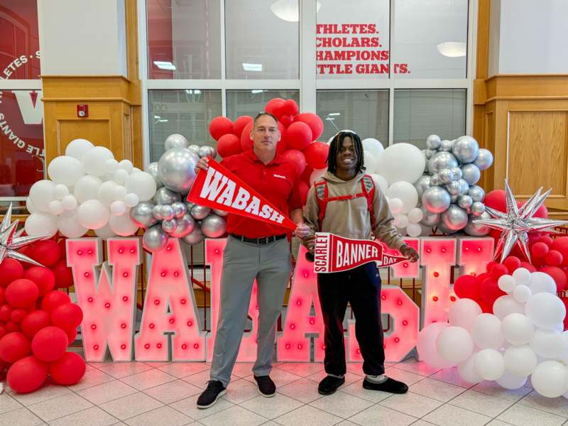 two men standing in front of balloons