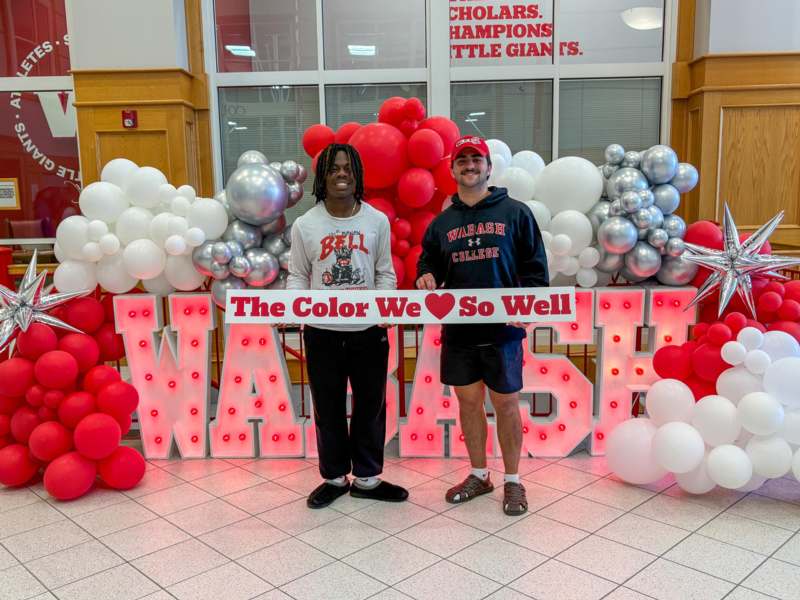 two men standing in front of balloons
