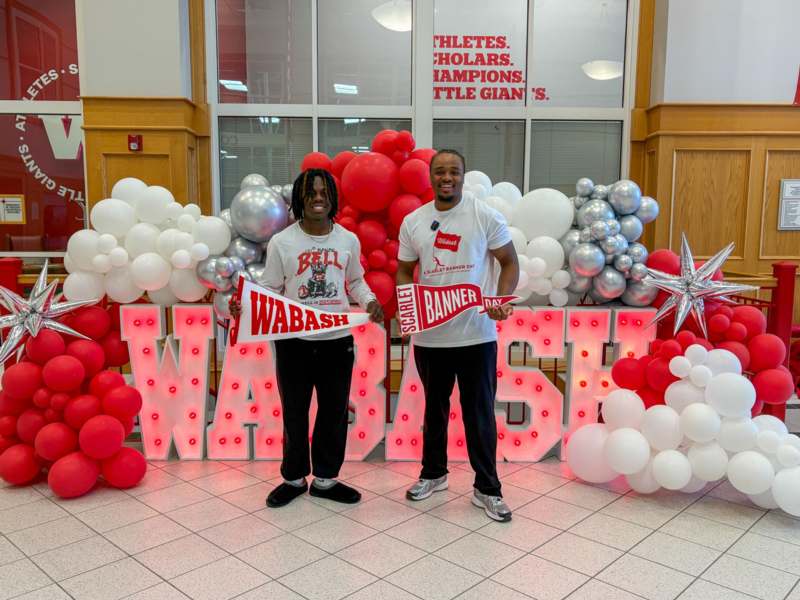 two men standing in front of balloons