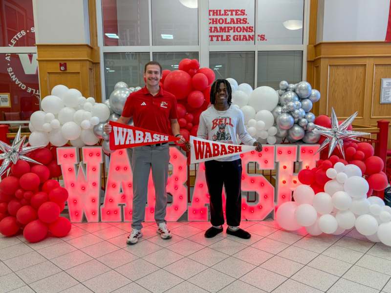 two men standing in front of balloons