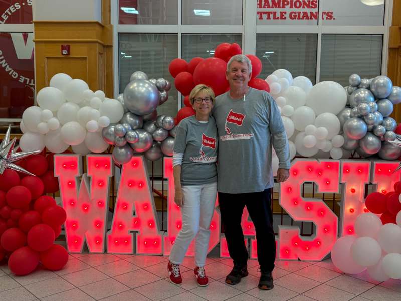 a man and woman standing in front of balloons