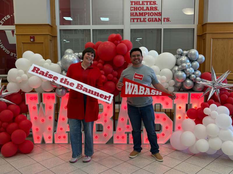 a man and woman holding signs