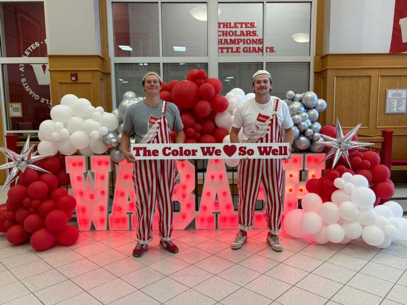 two men standing in front of balloons