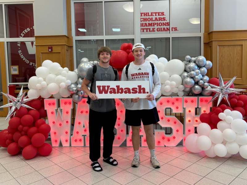 two men standing in front of balloons