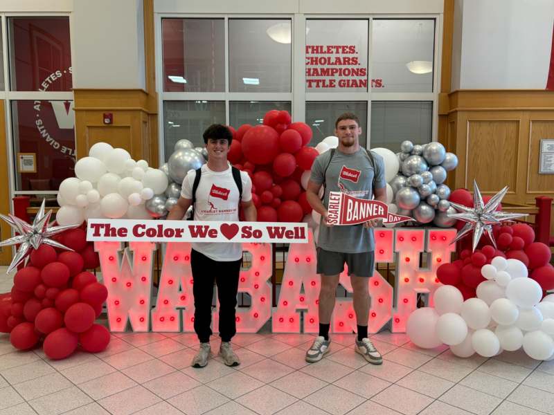 two men standing in front of balloons